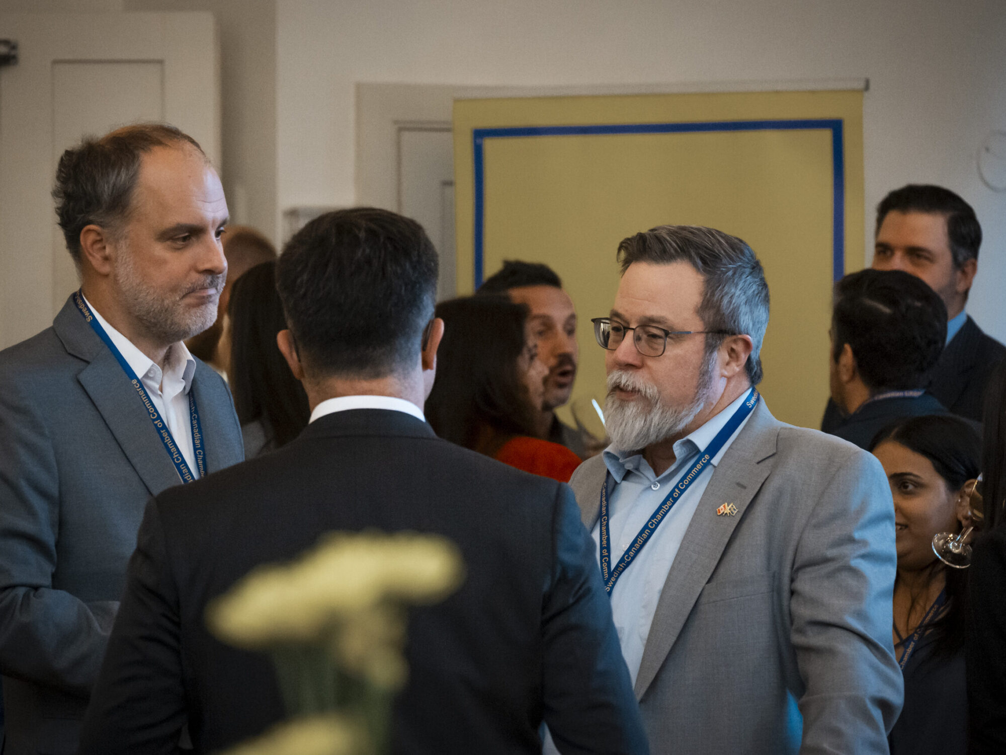 Overview image of people mingling and chatting at an event. Overview image of people mingling and chatting at an event.