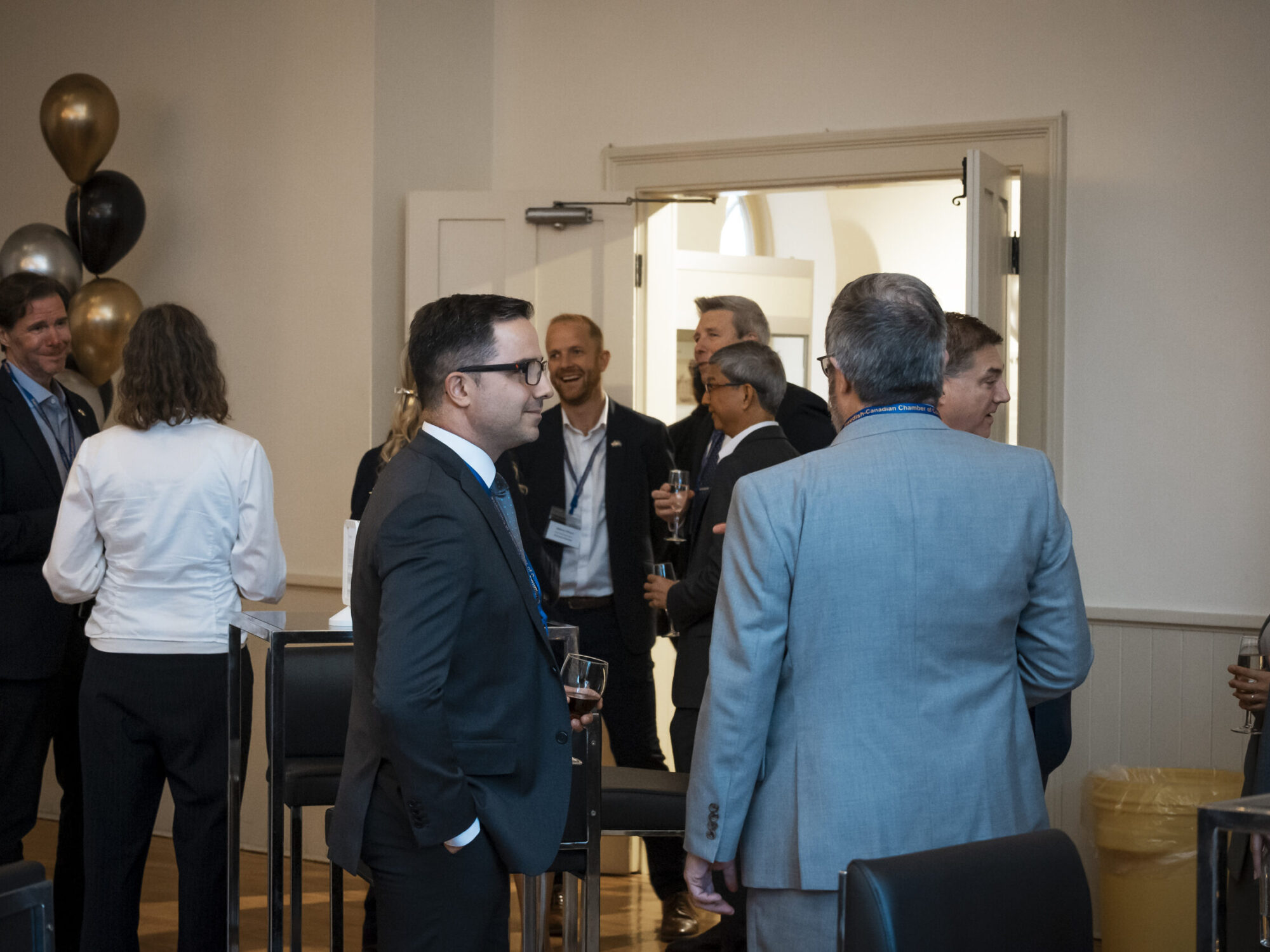Overview image of people mingling and chatting at an event.