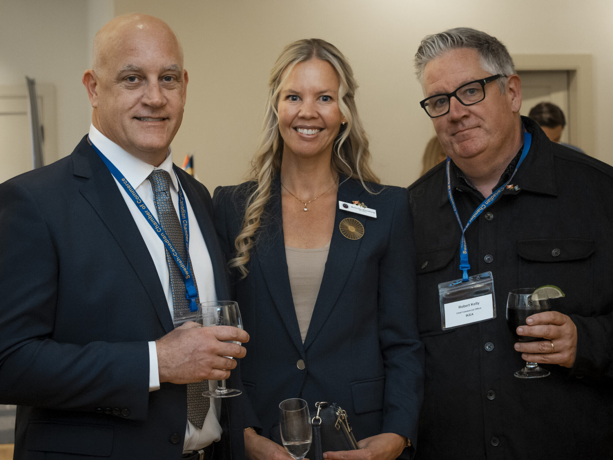 A woman and two men posing for a group photo at an event. A woman and two men posing for a group photo at an event.