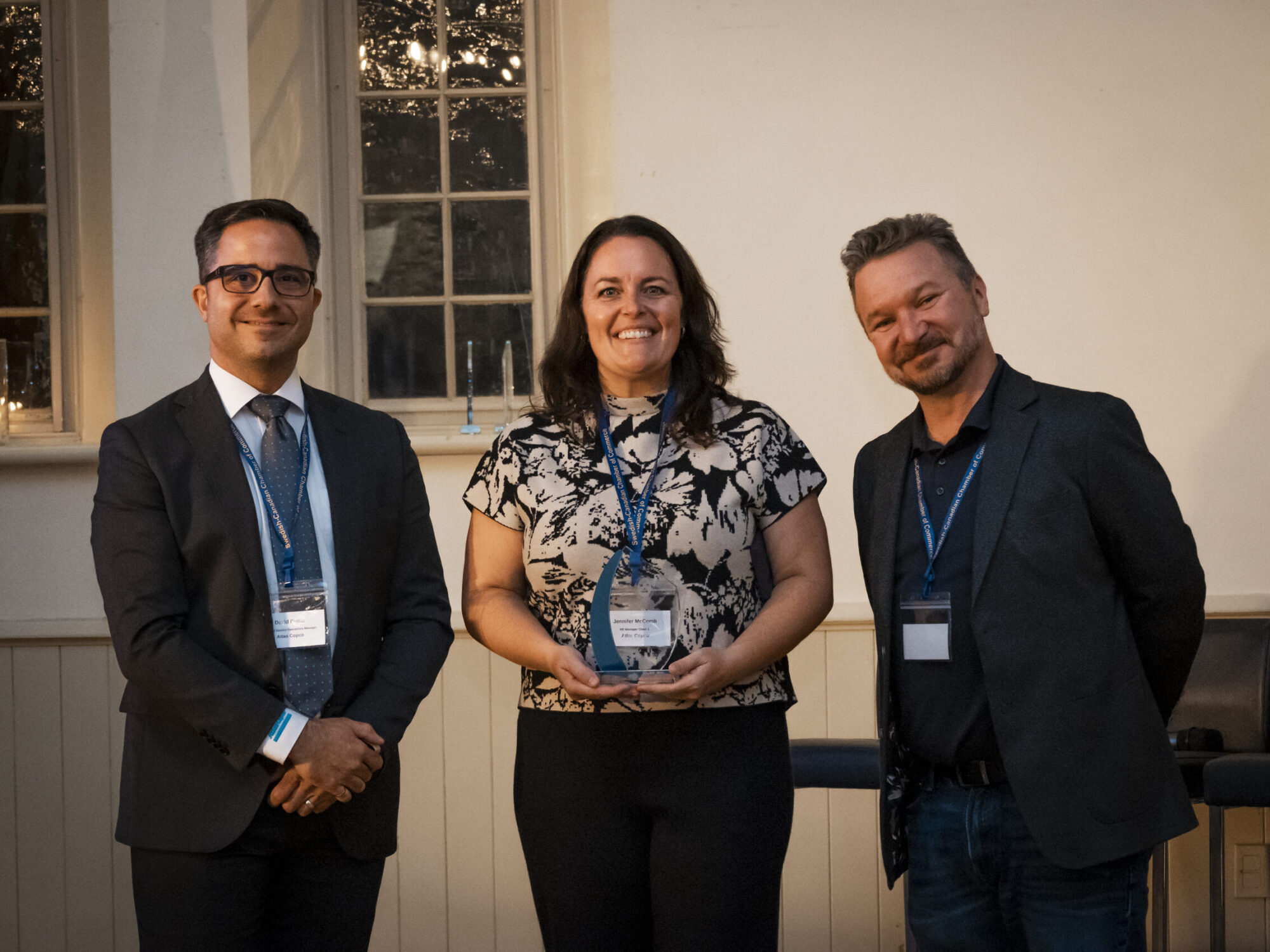 ferm-emelie_DSC2336_sccc-60th A woman and two men posing for a group photo while holding an award at a Swedish-Canadian Chamber of Commerce event.