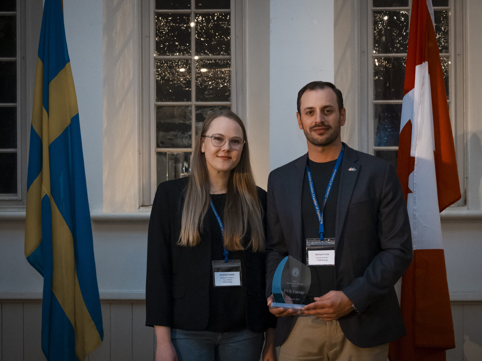 A man and a woman posing for a photo after being presented with an award. A man and a woman posing for a photo after being presented with an award.